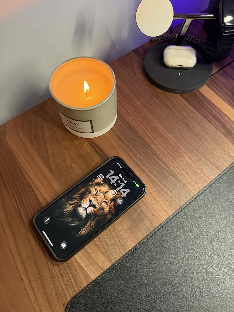 Téléphone posé sur le plateau en noyer Ergohide, au-dessus du chargeur sans fil invisible